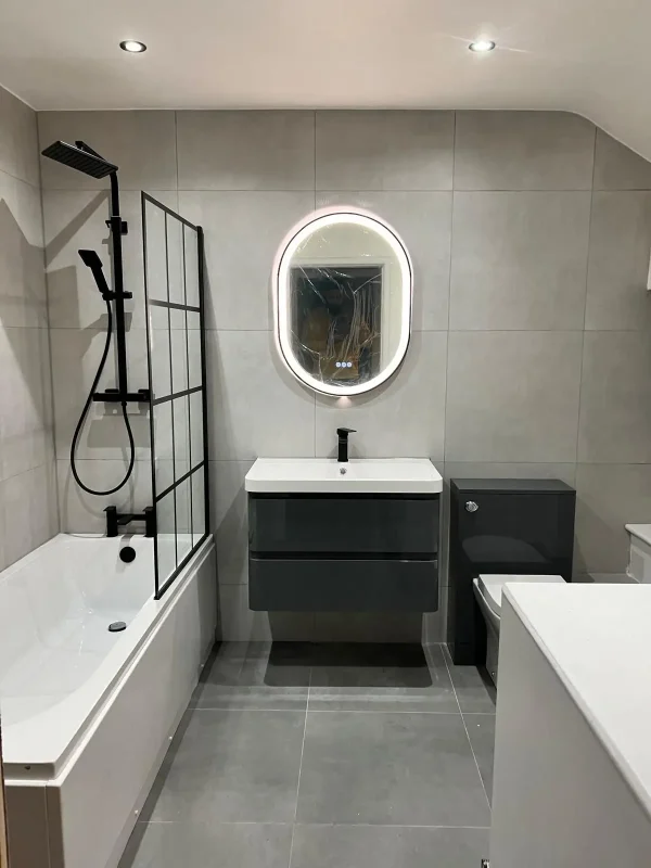 Modern grey bathroom renovation with black shower screen and wall-mounted vanity in Leeds