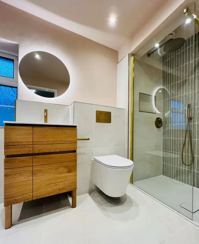 Completed bathroom renovation with oak vanity, walk-in shower and brushed brass details by AGUK Bathrooms