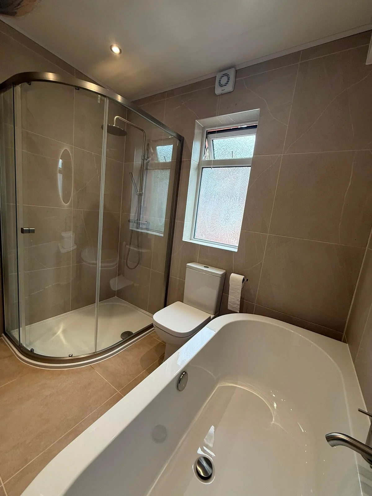 A family bathroom with a curved shower enclosure.