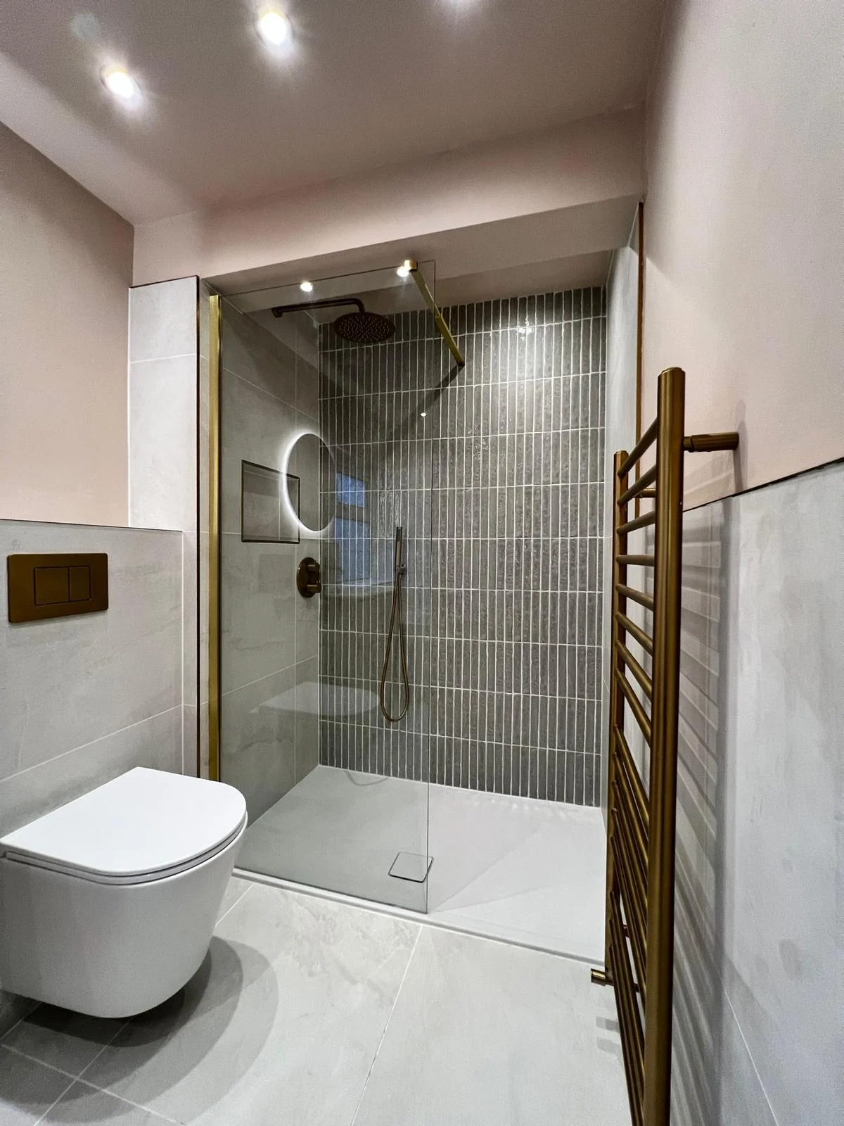A spacious walk-in shower with brushed brass finishes.